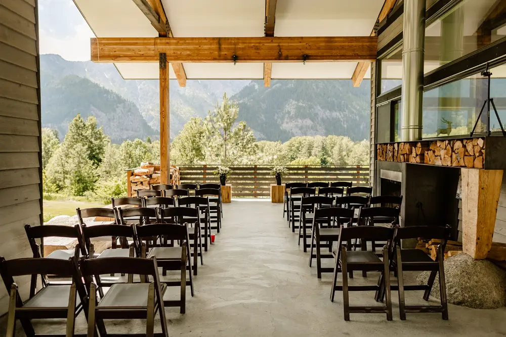 Covered patio wedding ceremony with chair rentals and mountain views in Washington