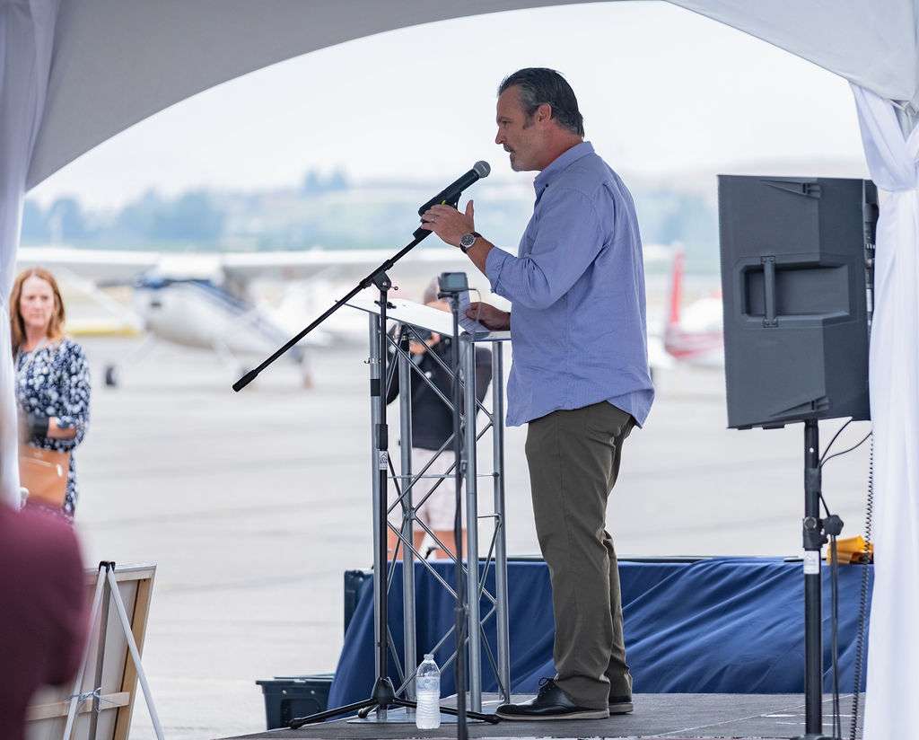 Corporate presentation set up under a rental tent with seating and staging for a company meeting