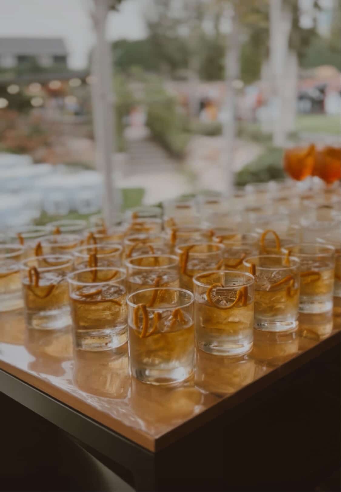 Rows of rock glass rentals with dehydrated orange garnish on a bar at an Eastern Washington wedding
