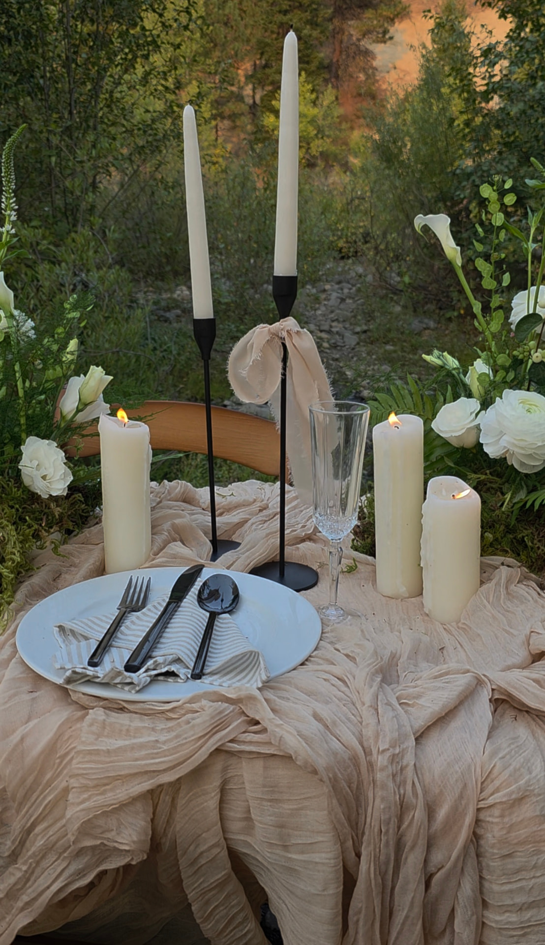 Wedding tablescape with ivory rentals, black candlesticks, tall taper candles and white calla lilies at an evening reception in Eastern Washington