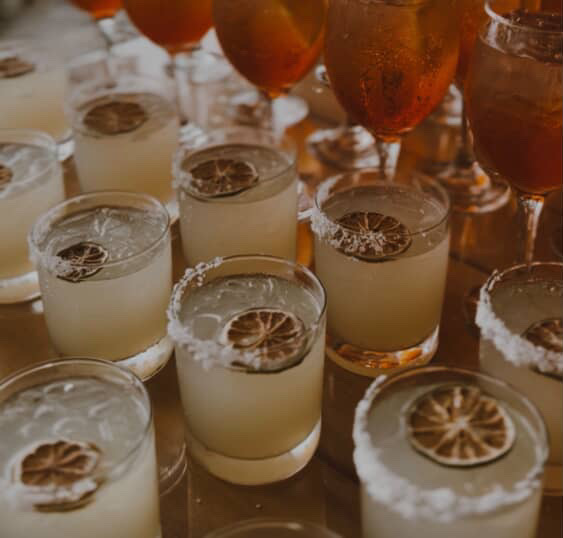 Mixed glassware rentals including wine glasses and rocks glasses staged for a wedding cocktail hour