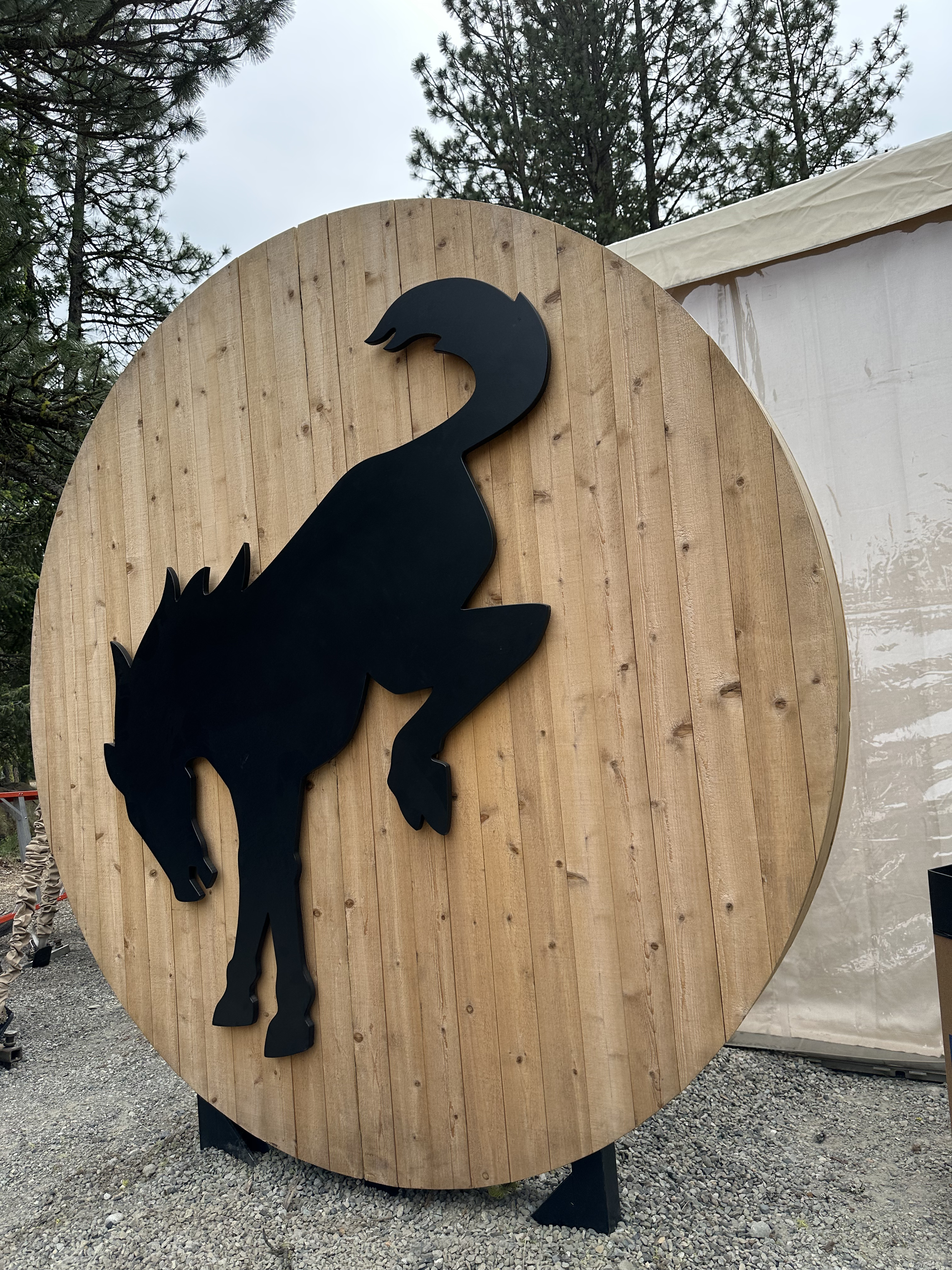 Ford Bronco brand activation with a custom bucking-bronco wood sign beside a white event tent in the pines at Suncadia Resort near Cle Elum, WA — corporate event rentals by NCW Event Rentals