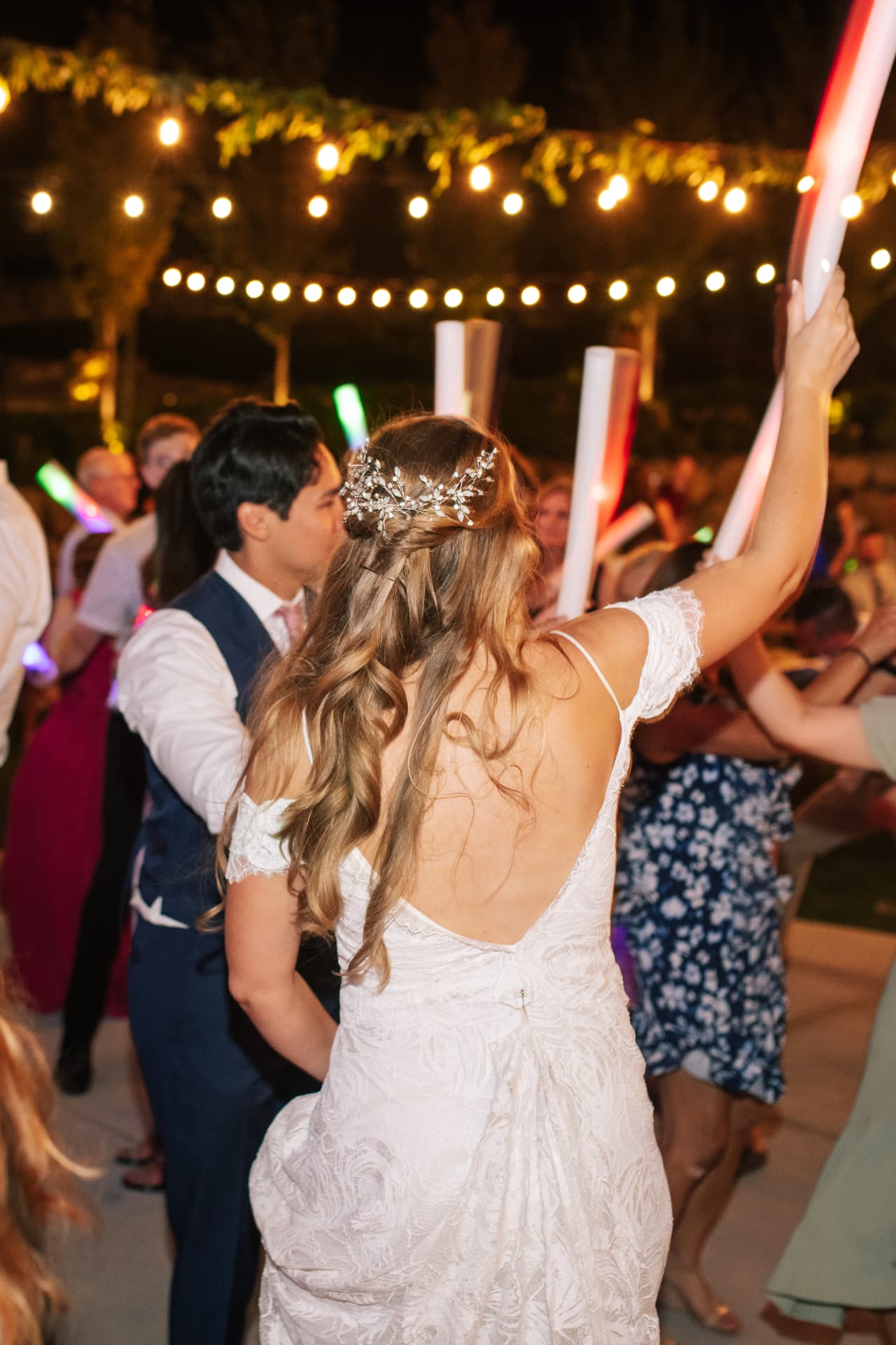 Bride dancing with glow sticks on a white dance floor at a nighttime Cle Elum wedding reception under string lights