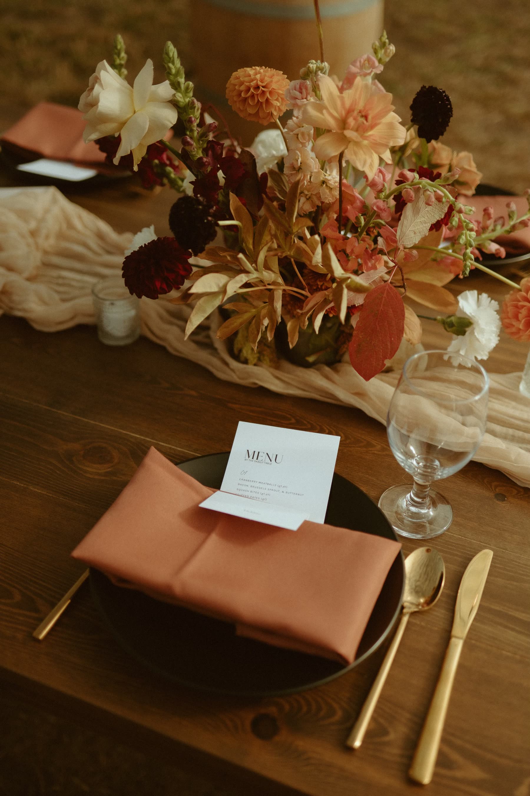 Farmhouse table place setting with printed menu, taper candles and greenery runner